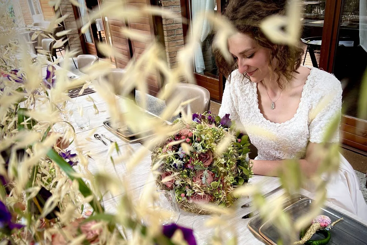 Sposa con un bouquet di fiori di campo e spighe
